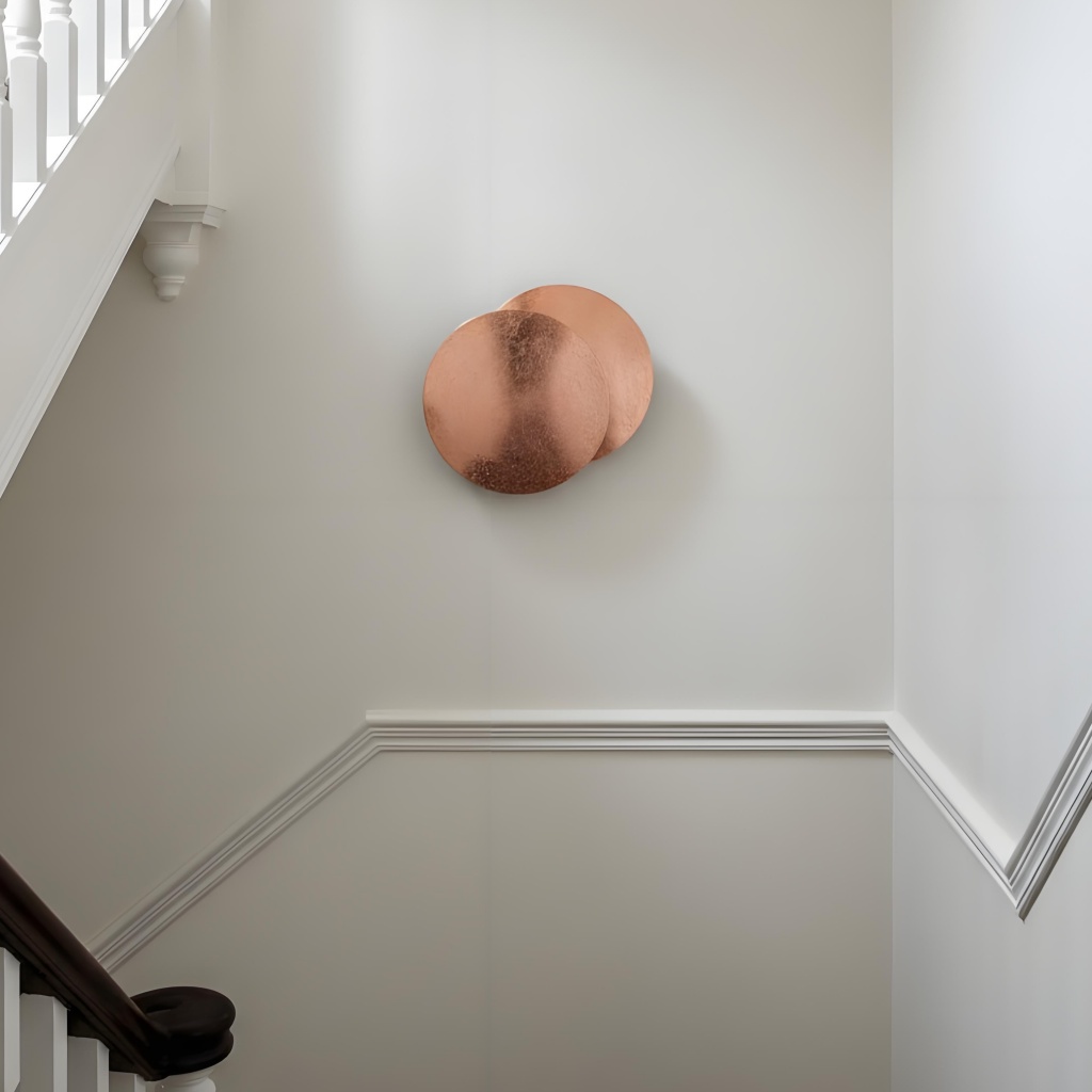 Copper Discola wall light by a staircase