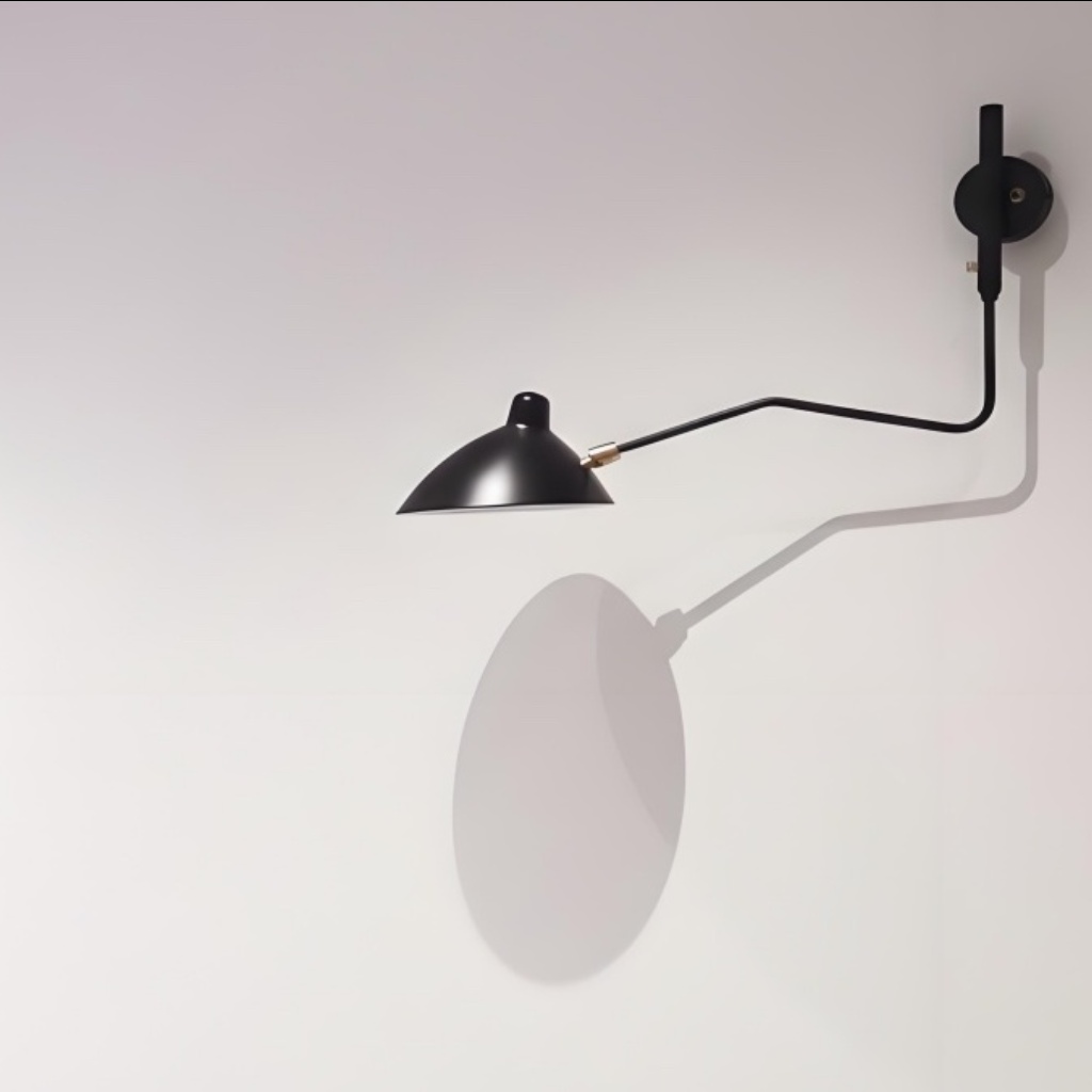 Black Arclume wall light casting a shadow
