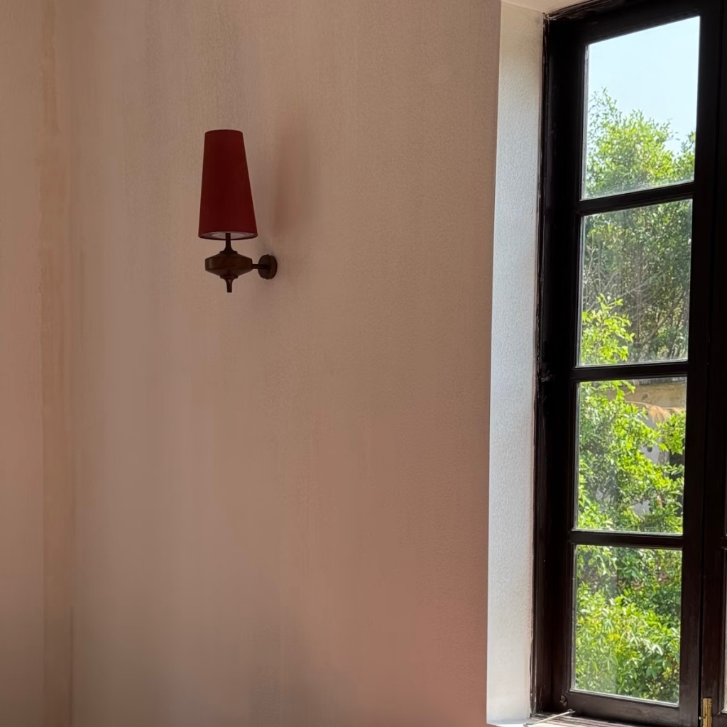 Installed red Luma wall lamp by a window