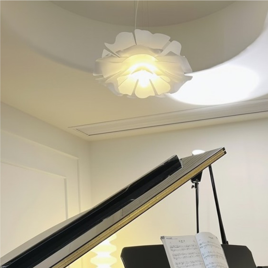 Flower pendant light glowing near a piano