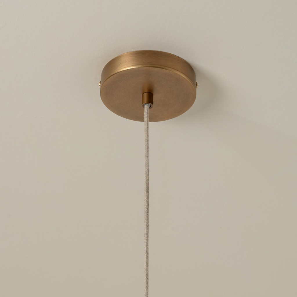 Warm brass-toned ceiling canopy and hanging cord detail