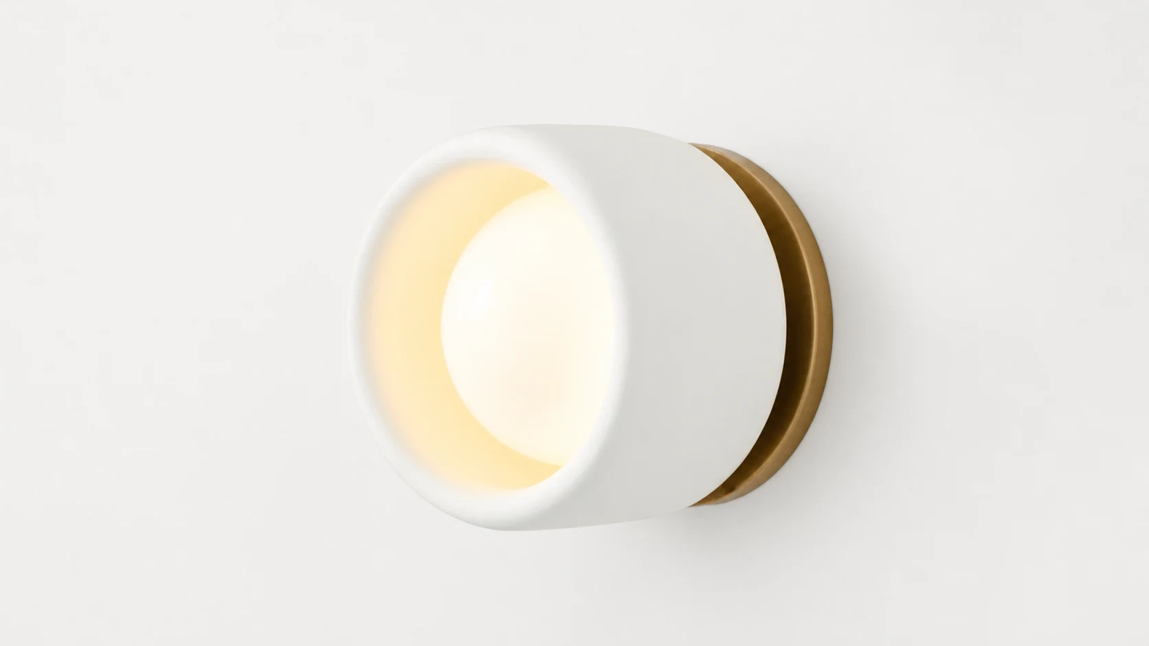 Cerova ivory porcelain bronze wall sconce in a soft room setting